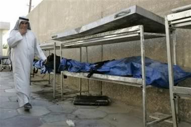 A man walks past body bags containing beheaded bodies outside the Yarmouk hospital morgue in Baghdad September 12, 2006. (Ali Jasim/Reuters)